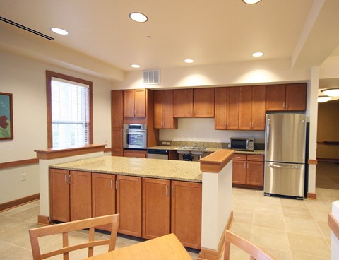 a large kitchen with wooden cabinets and a counter top at Cambridge Senior Living
