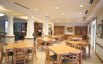 a large dining room with tables and chairs at Senior Living at Cambridge Heights