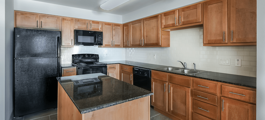 a kitchen with black appliances and wooden cabinets