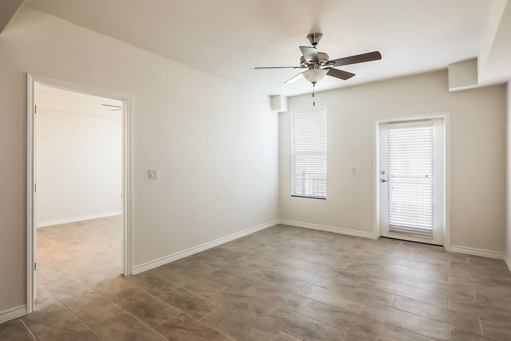a living room with a ceiling fan and a door