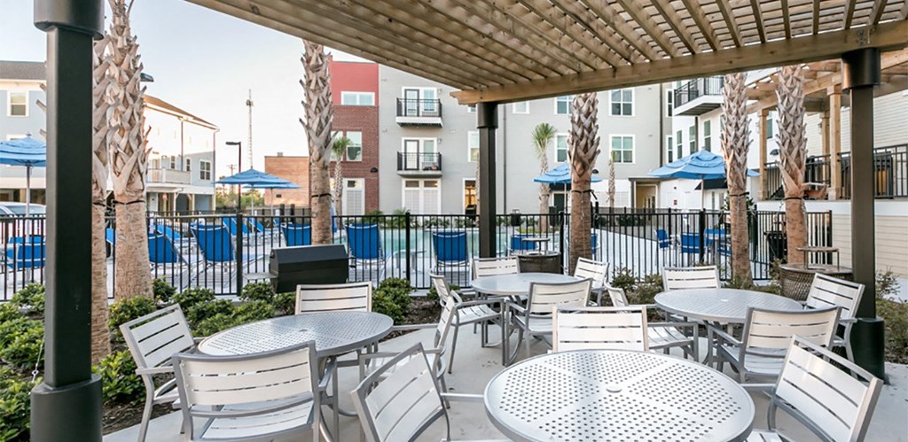 a patio with tables and chairs outside of an apartment building