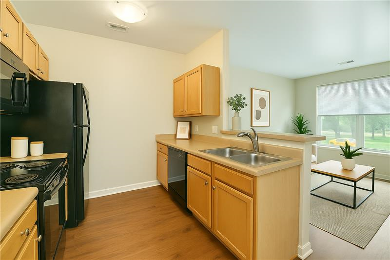 A kitchen with wooden cabinets and a black fridge.
