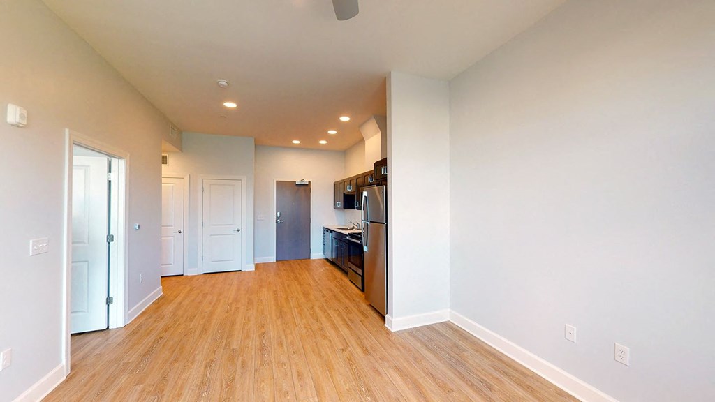 a renovated living room and kitchen with wood floors at City Square 162