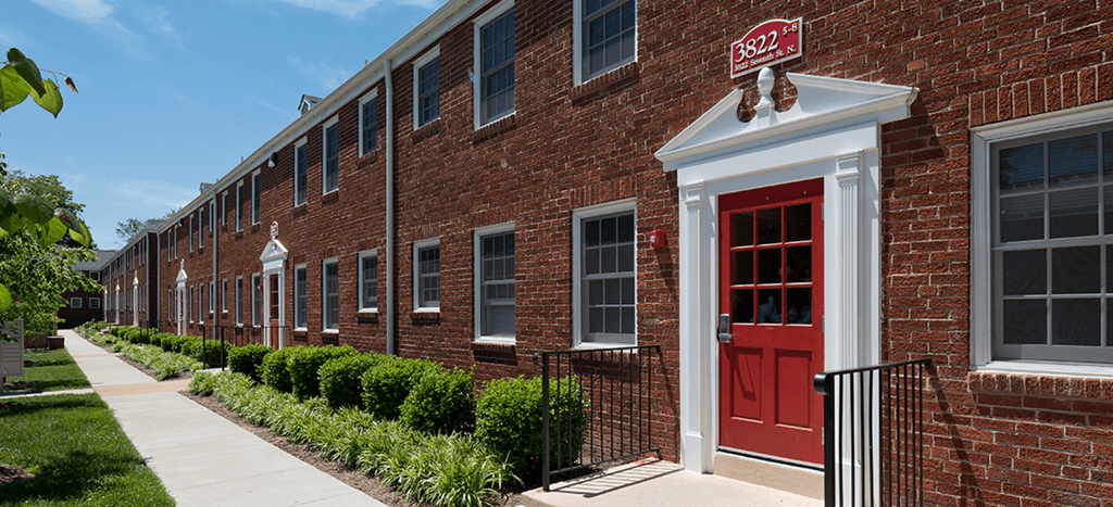Clarendon Court Apartments a brick apartment building with a red door at Clarendon Court