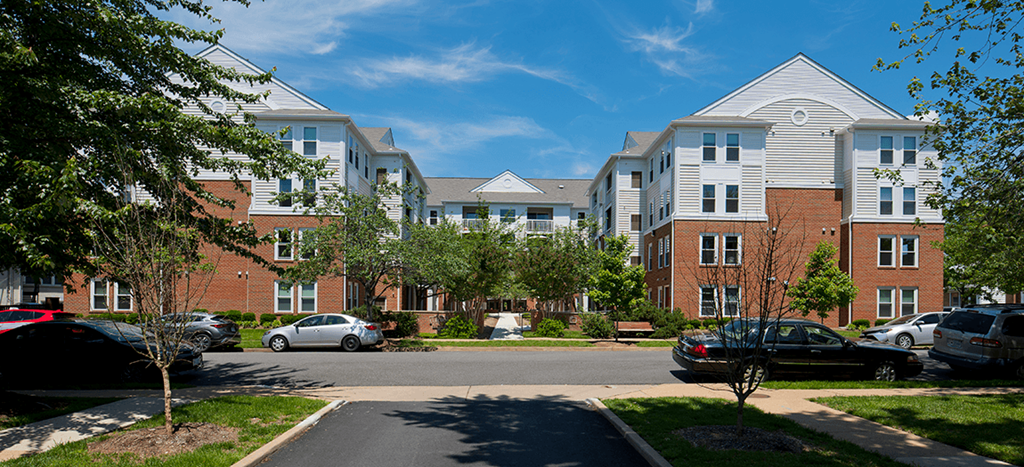 Clarendon Court Apartments an apartment building with cars parked in front of it