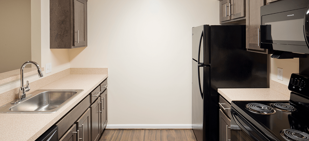 an empty kitchen with a sink and a refrigerator