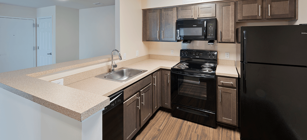 a model kitchen with black appliances at Clarendon Court Apartments