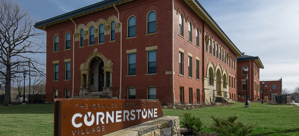 a brick apartment building with a sign in front of it