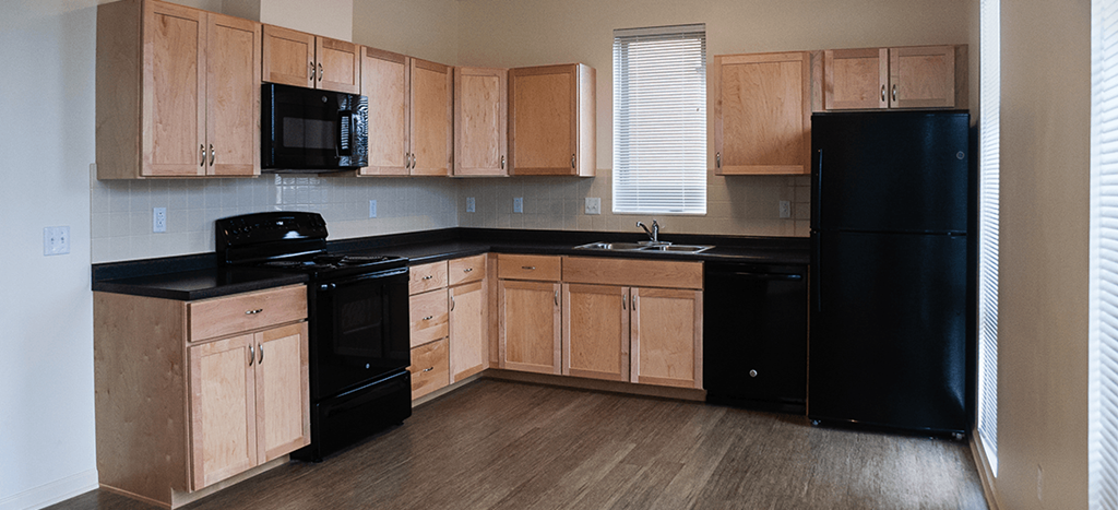 a kitchen with black appliances and wooden cabinets
