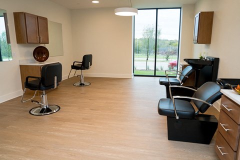 A living room with black chairs and wooden floors.