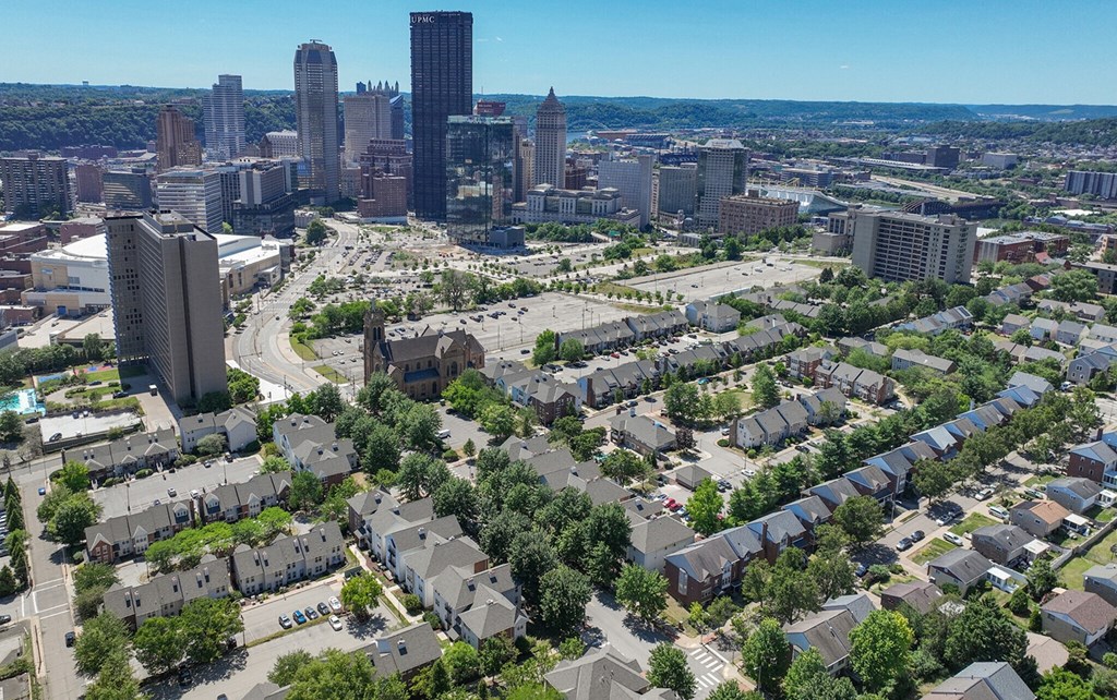an aerial view of Pittsburgh with houses and a city skyline at Crawford Square Apartments & Townhomes