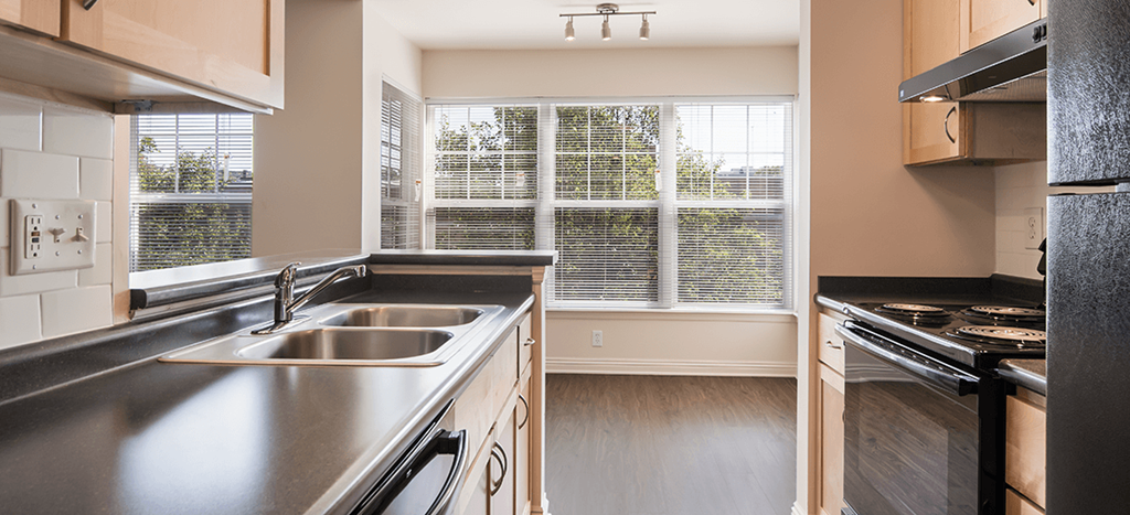 an empty kitchen with a sink and a window at Crawford Square apartments