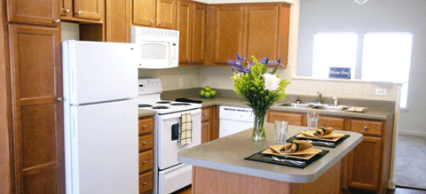 a kitchen with white appliances and wooden cabinets