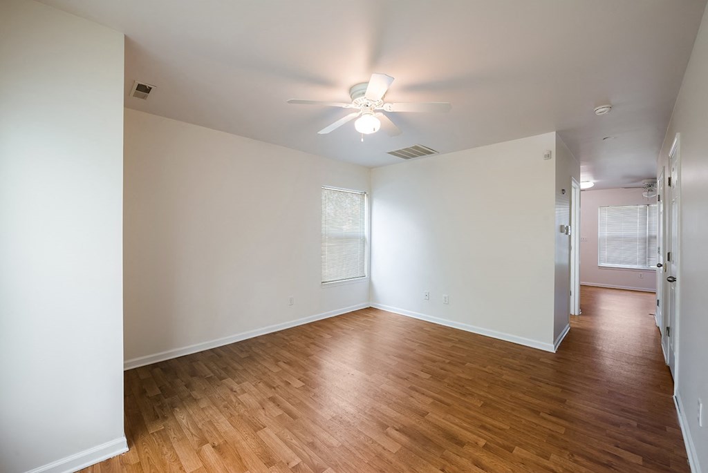 an empty living room with wood floors and a ceiling fan at Duneland Village apartments and Townhomes in Gary, IN