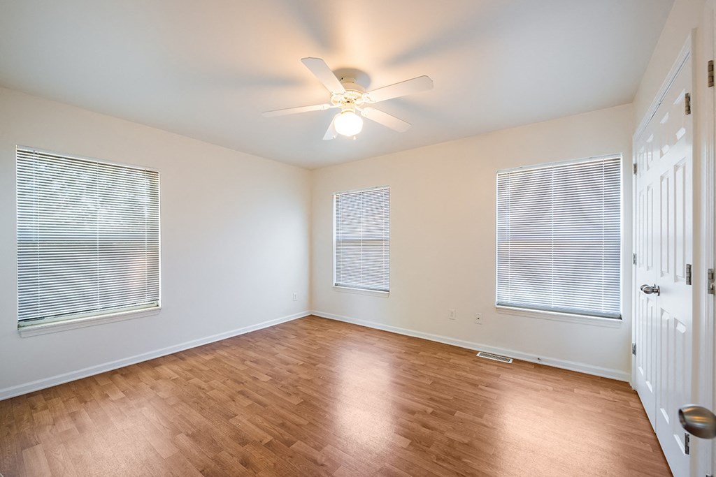 an empty living room with wood floors and a ceiling fan at Duneland Village apartments and Townhomes in Gary, IN
