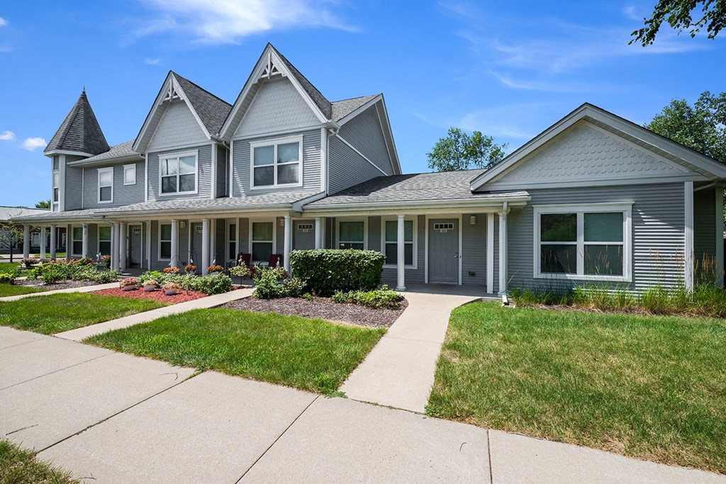 a gray townhouse with a sidewalk in front of it at Duneland Village apartments and Townhomes in Gary, IN