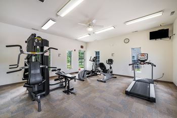 a gym with treadmills and other exercise equipment and a tv at Duneland Village apartments and townhomes in Gary, IN