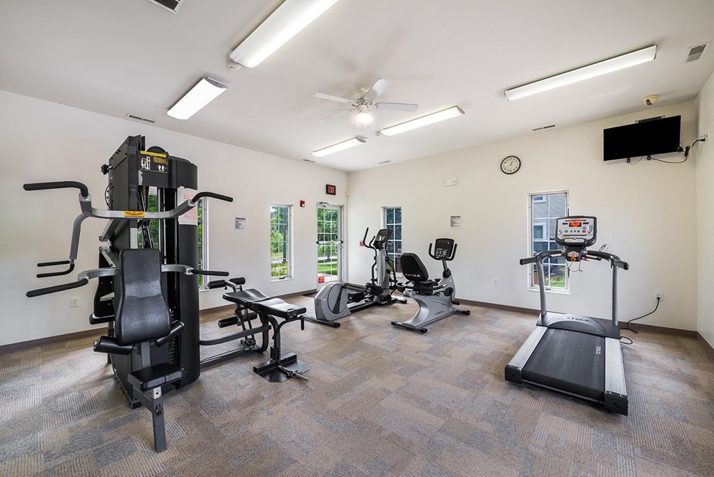 a gym with treadmills and other exercise equipment and a tv at Duneland Village apartments and Townhomes in Gary, IN