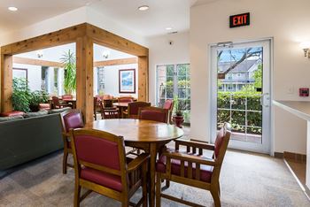 a dining area with a wooden table and chairs and a door to a living room