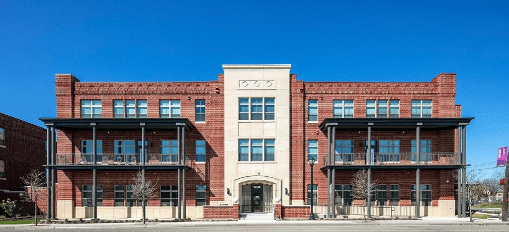 the front of a red brick building with a blue sky