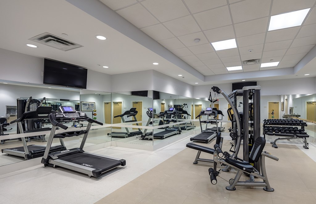 a gym with treadmills and other exercise equipment in a large room
