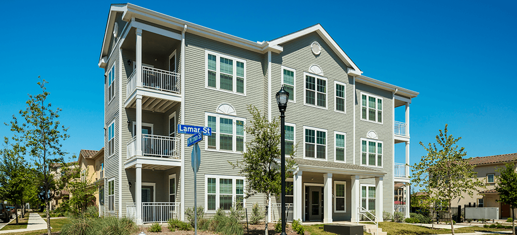 an apartment building with a street sign in front of it