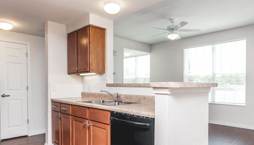 an empty kitchen with a sink and a ceiling fan at East Meadows apartments in San Antonio, TX
