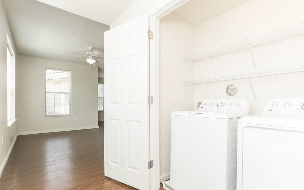 an empty laundry room with two washes and a dryer at East Meadows apartments in San Antonio, TX