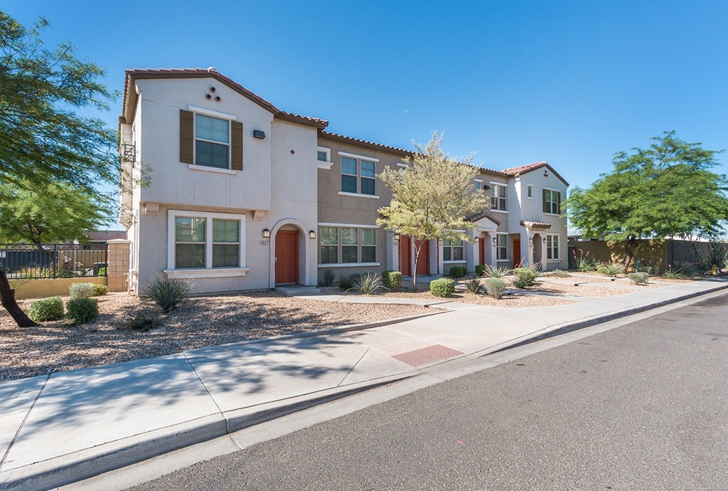 A two-story house with a red door and white walls.