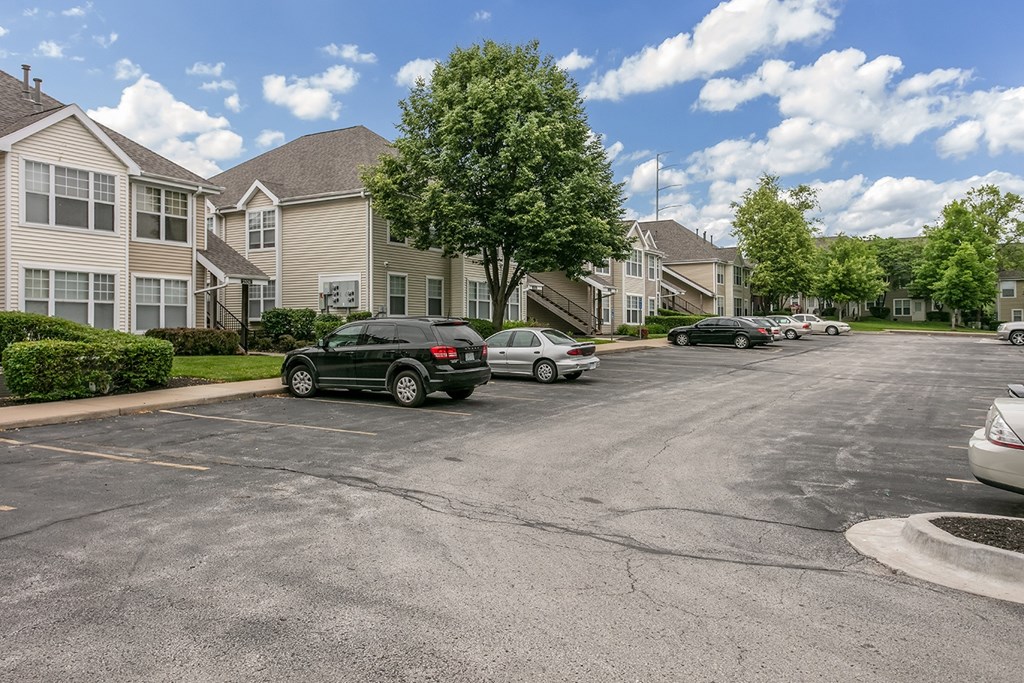 A parking lot with cars and apartment buildings in the background.