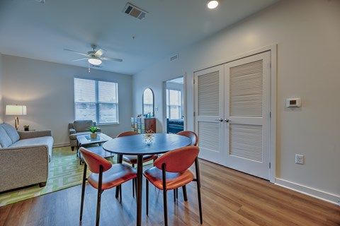 A dining room with a round table and four chairs.