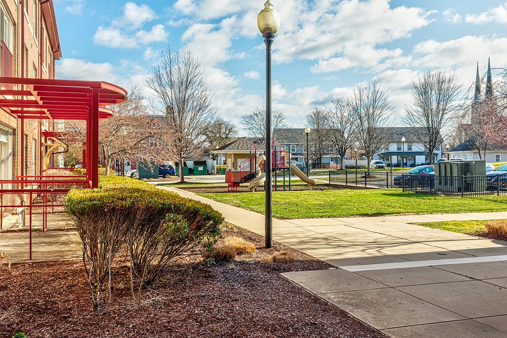 A street view with a red pole and a building in the background.