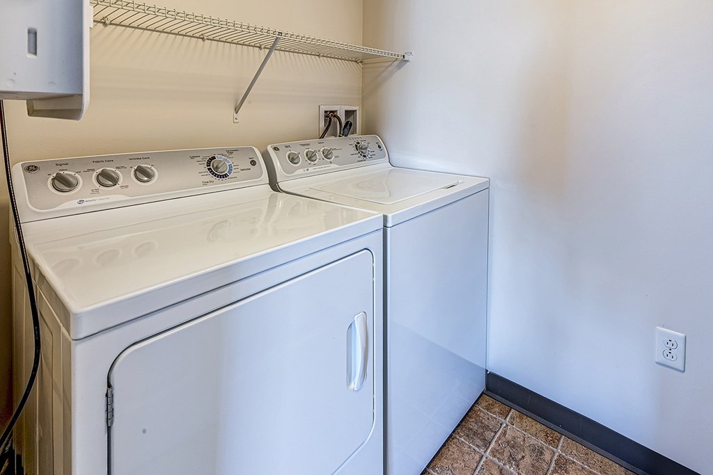 A white washing machine and dryer in a small laundry room.