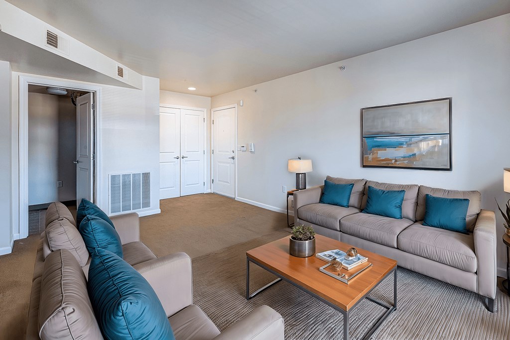 A living room with a couch, chairs, and a coffee table.