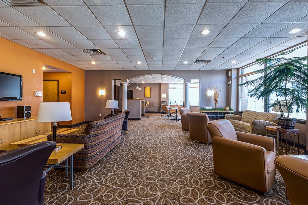 A large room with a carpeted floor and a long couch.