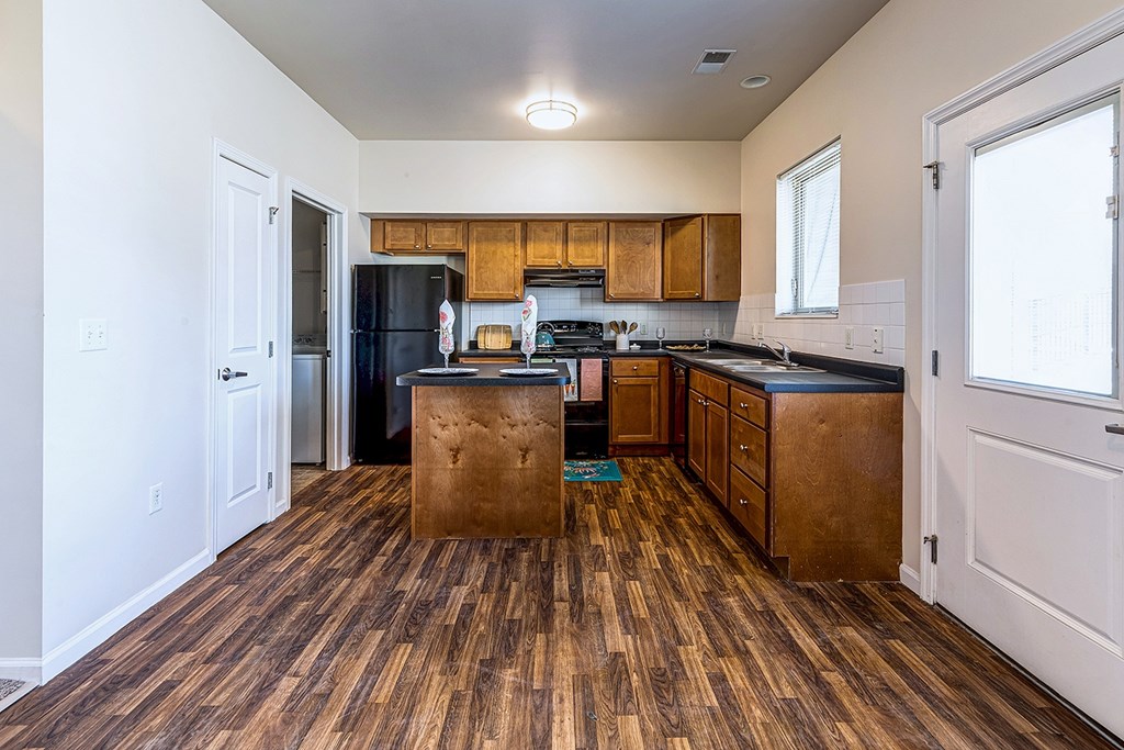 A kitchen with wooden floors and white walls.