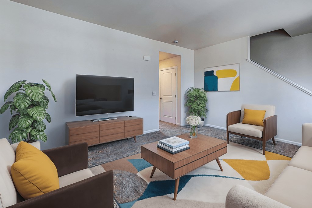 A living room with a brown sofa, a brown coffee table, a white armchair, a wooden cabinet, a television, and a potted plant.
