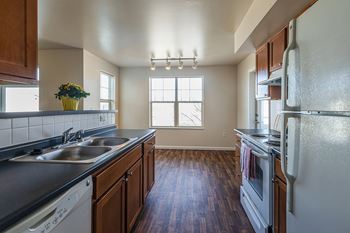 A kitchen with wooden cabinets and a white refrigerator.