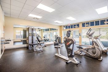A gym with a treadmill, elliptical machines, and other exercise equipment.