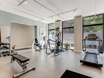 the gym has plenty of exercise equipment and floor to ceiling windows