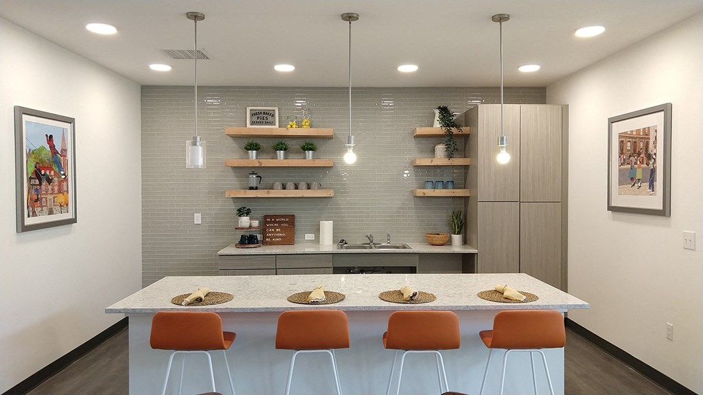 a kitchen with a counter and chairs in front of a table