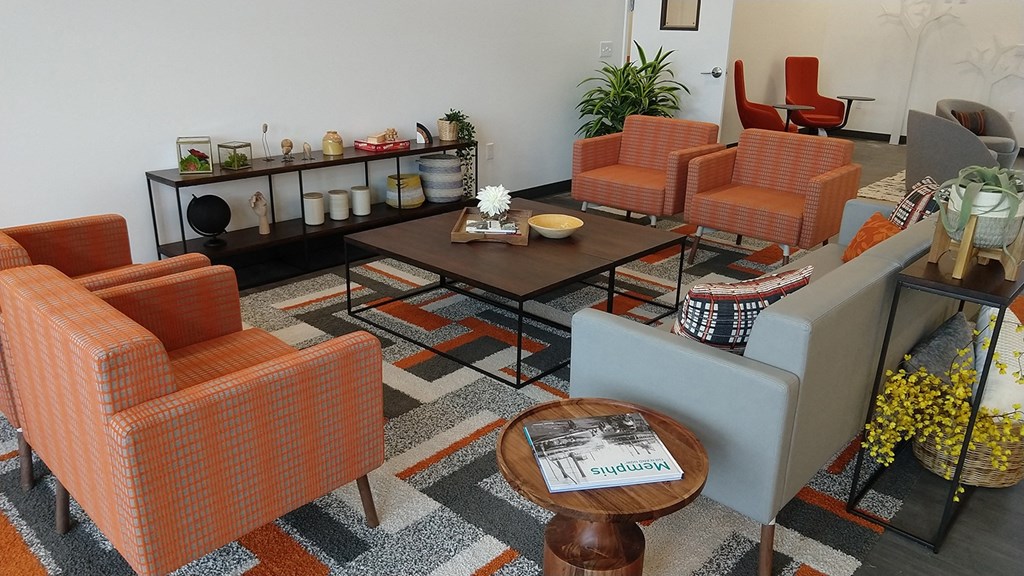 a living room with orange chairs and a coffee table