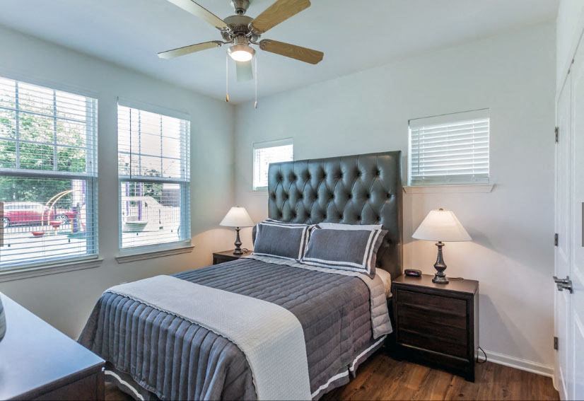 a bedroom with a large bed and a ceiling fan