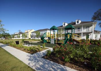 a playground in a park in front of apartments