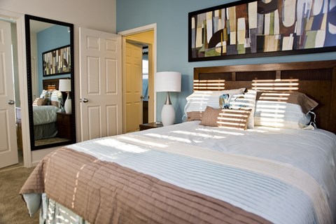 a bedroom with a large bed and a mirror
