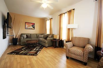 a living room with a wood floor and a couch and a chair
