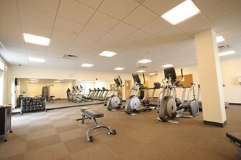 a gym with cardio equipment and weights in a building