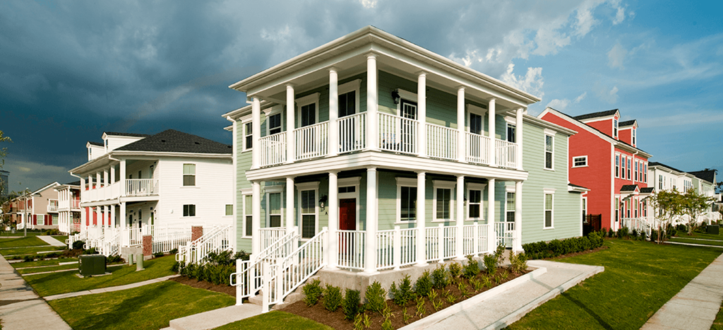 a row of mulit-color apartment homes with a lawn at Harmony Oaks Apartments