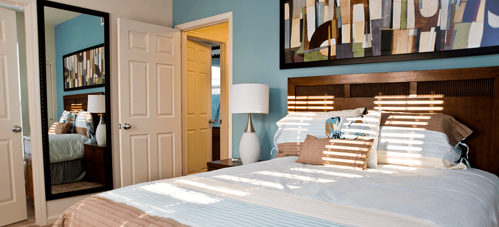 a bedroom with a bed and a mirror and a closet at Harmony Oaks Apartments