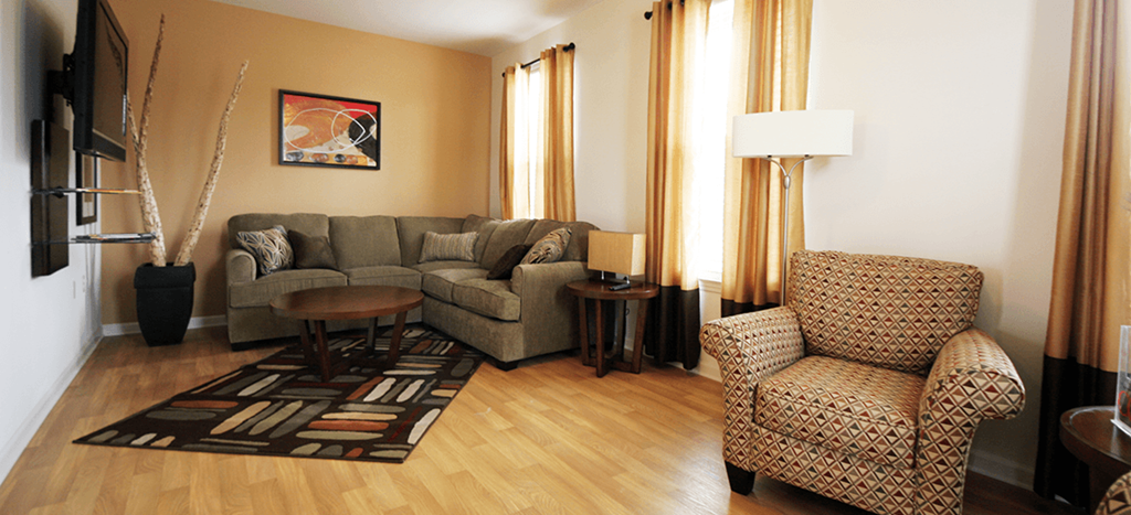 a living room with a couch and two chairs at Harmony Oaks Apartments